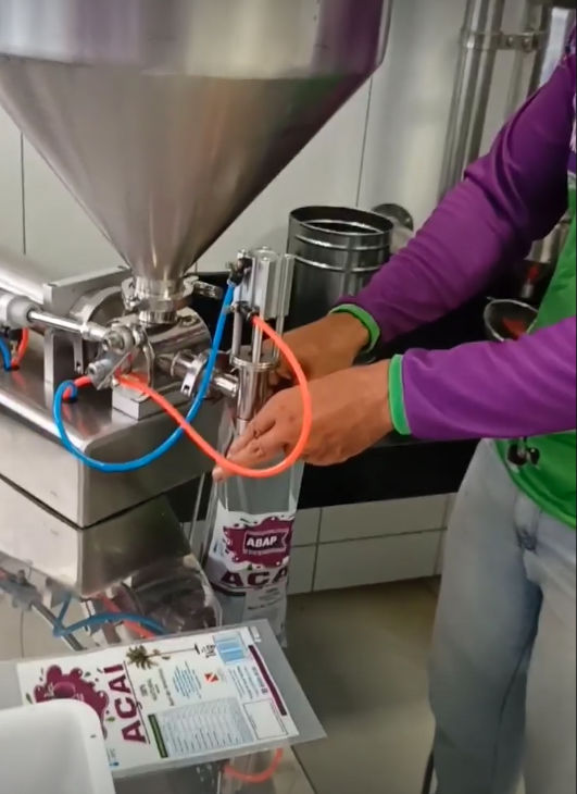 Associada da ABAP operando máquina de envase de açaí em produção local